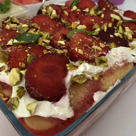 Tiramisu z truskawkami i pistacjami w szklanym naczyniu